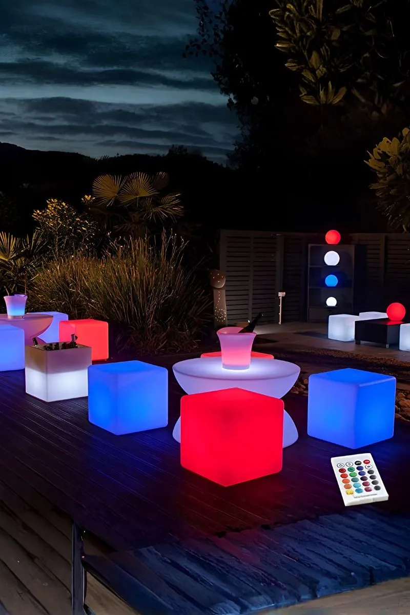 Sillas LED iluminadas al aire libre sobre césped artificial en terraza nocturna